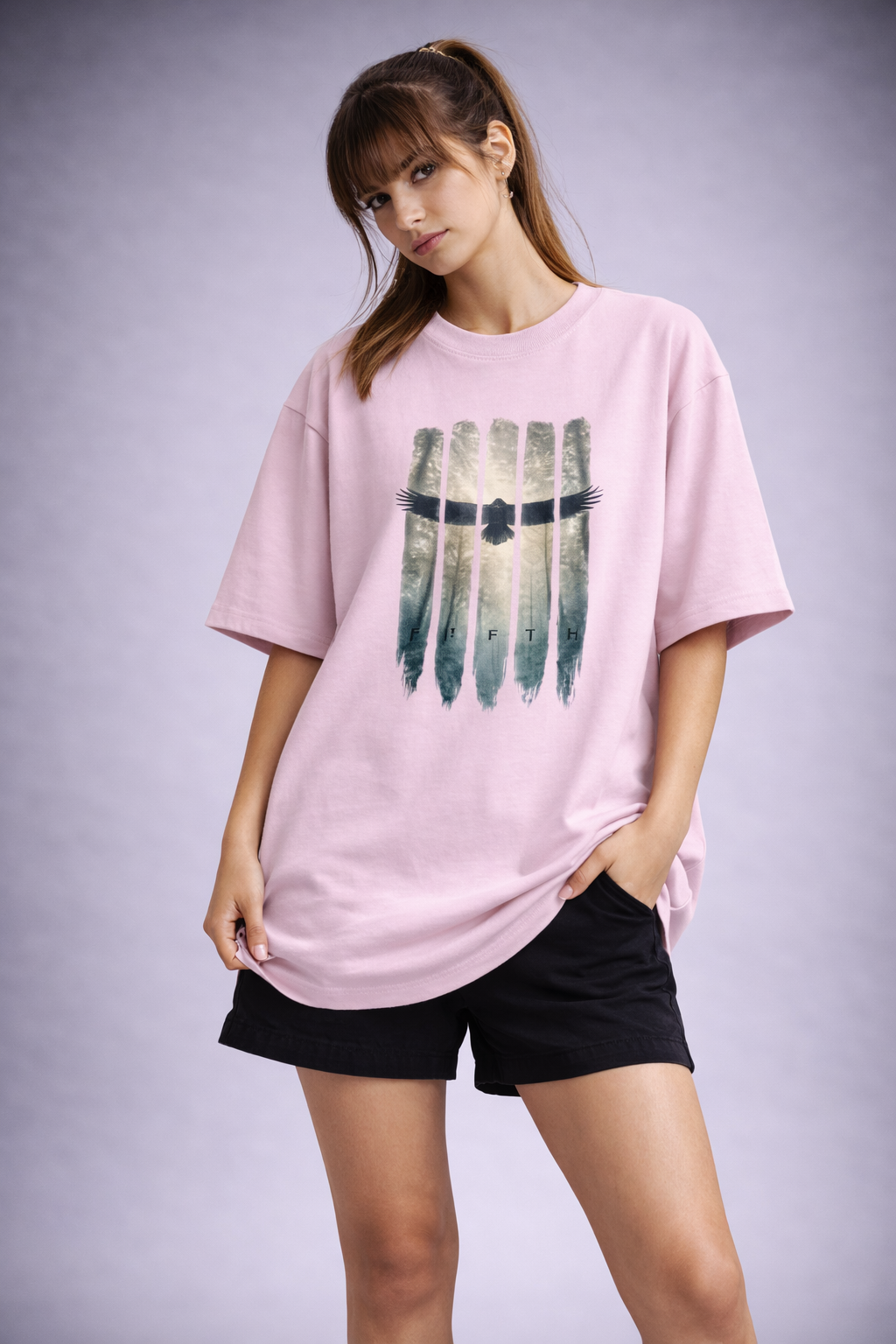 Woman wearing a pink t-shirt with a graphic design on a plain background