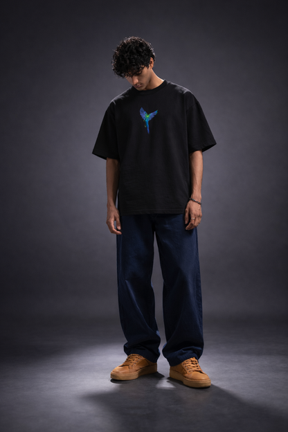 Person wearing a black t-shirt with a blue logo on a dark background