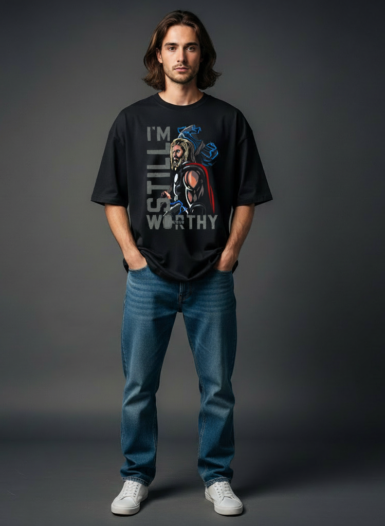 Person wearing a Thor inspired black t-shirt with a graphic design and text, standing against a gray background